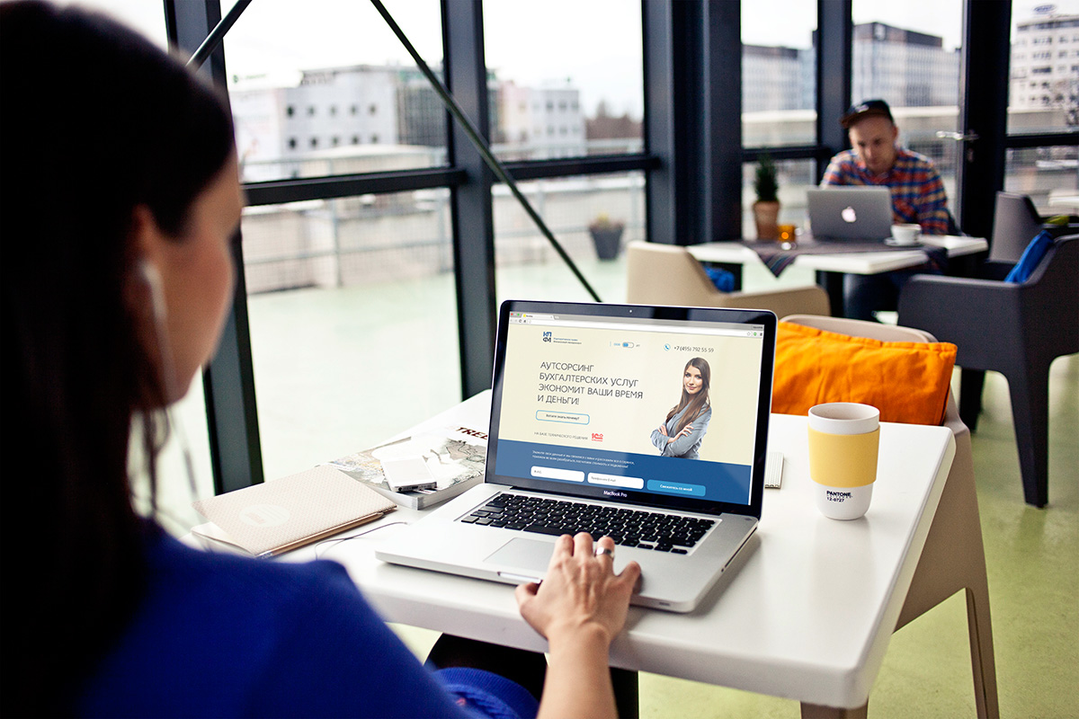 первый экран лендинга КПФМ 1С на ноутбуке в кафе